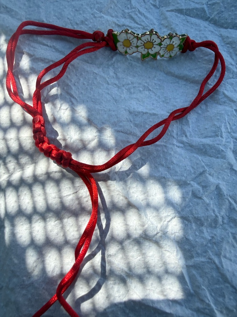 Three Flower Petals With A Red String Bracelet